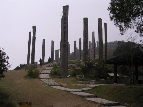 1999 Toyota Tacoma - A scenic view of ancient stone pillars and a traditional pavilion on a hill, with a paved walkway leading through the landscape.