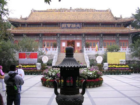 1999 Toyota Tacoma - A large temple structure with traditional architecture, surrounded by colorful flowers and a paved courtyard.