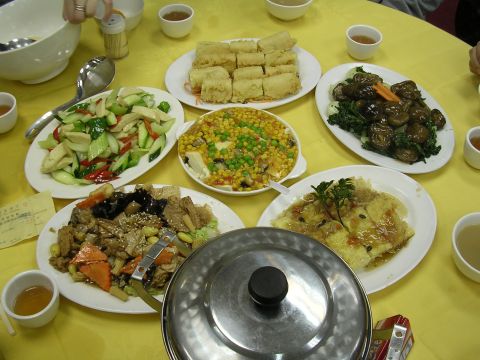 1999 Toyota Tacoma - A spread of various Chinese dishes is laid out on a yellow tablecloth, ready for a meal.