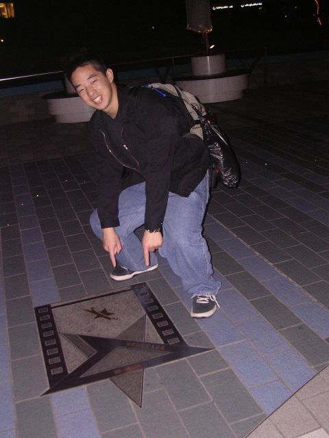 1999 Toyota Tacoma - A man points to a star-shaped inlay on the ground, possibly a landmark.