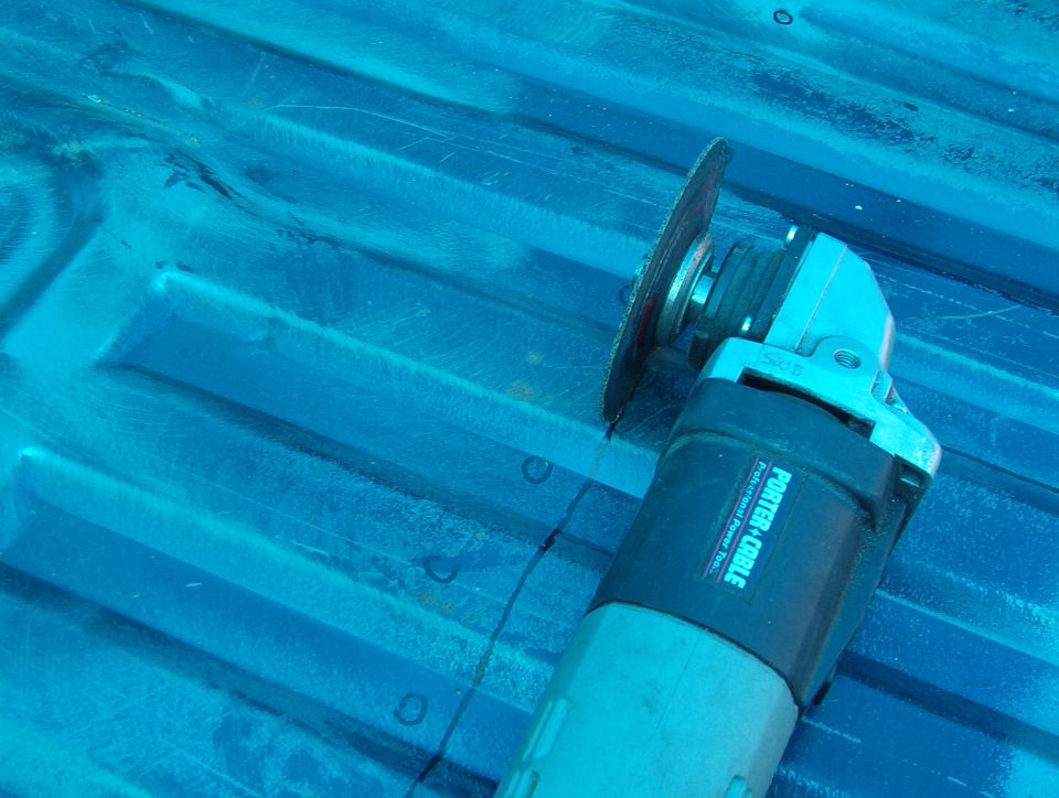 Porter-Cable angle grinder lying on a blue truck bed, tinted blue lighting