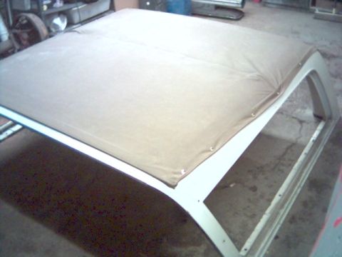 1986 Ford Bronco - The frame for a vehicle's soft top is shown, covered with a tan fabric material.