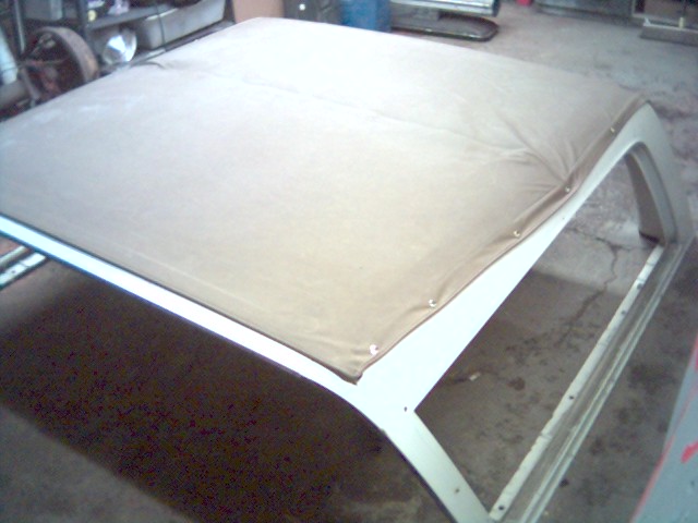 soft top frame with tan fabric stretched over it, inside a garage