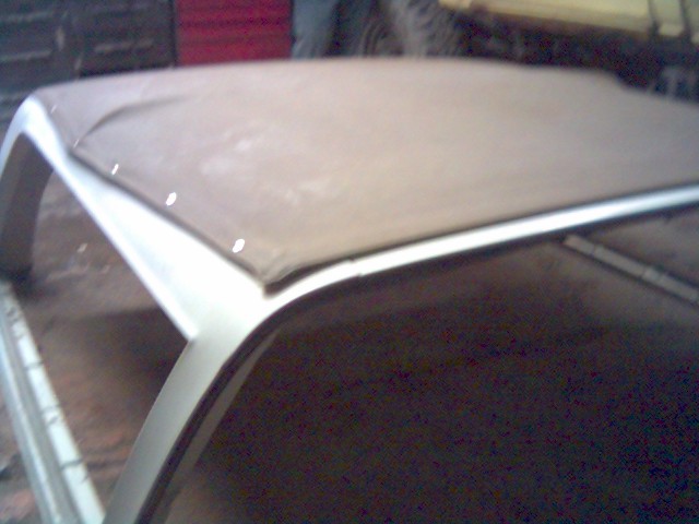 Soft top frame with tan fabric cover, showing attachment points