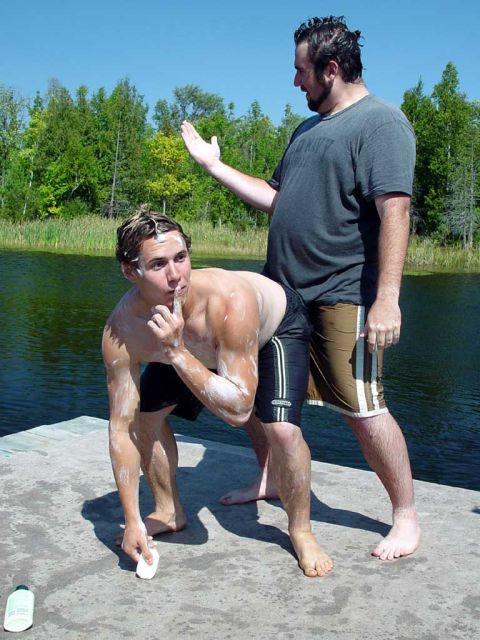 1991 Ford Bronco - Two men are on a dock by a lake, with one man making a shushing gesture while the other looks on.