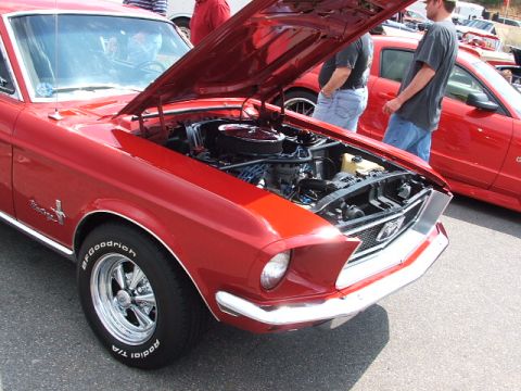1966 Ford Ranchero - A red 1967 Ford Mustang is displayed with its hood open, revealing the engine bay and polished wheels.