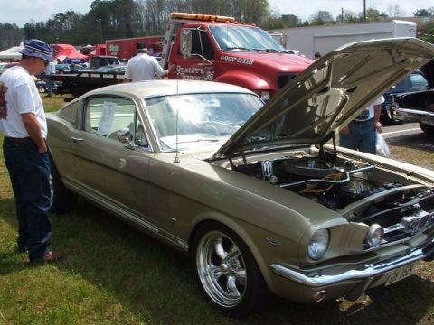 1966 Ford Ranchero - A 1966 Ford Mustang coupe is displayed with its hood open, a tow truck visible behind it.