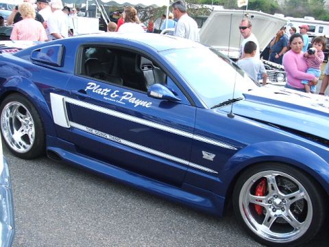1966 Ford Ranchero - A blue Ford Mustang is parked outdoors with people in the background.