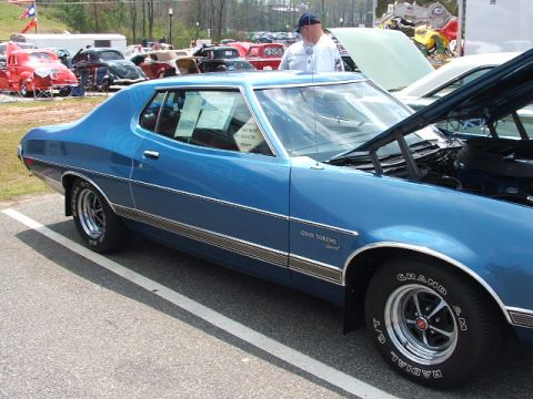 1966 Ford Ranchero - Blue 1972 Ford Gran Torino Sport with hood open at a car show.