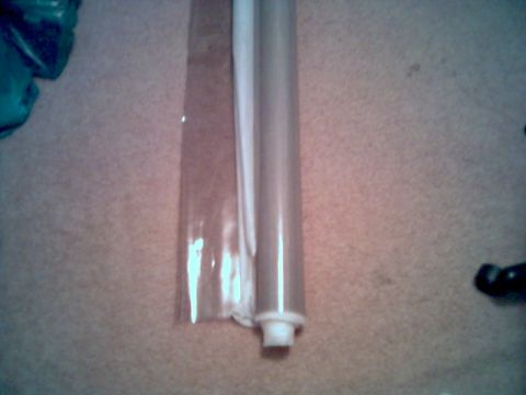 1986 Ford Bronco - A close-up view of rolled plastic sheeting and a cylindrical object on a textured surface.