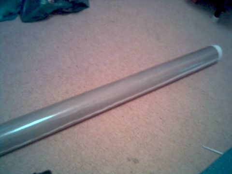 1986 Ford Bronco - A metal tube is shown on a carpeted surface, with a white cap on one end.
