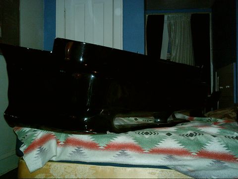 1995 Ford Probe - A black car bumper rests on a blanket in front of a door.