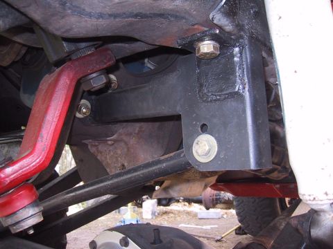 1990 Ford Bronco - Close-up view of the undercarriage of a vehicle, showing various mechanical components and suspension elements.