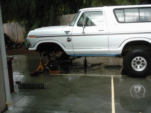 1978 Ford Bronco - 1978 Ford Bronco undergoing front suspension work, jacked up with parts laid out.