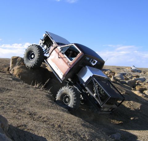 1981 Ford Bronco - This heavily modified truck navigates a rocky incline, its off-road capabilities.