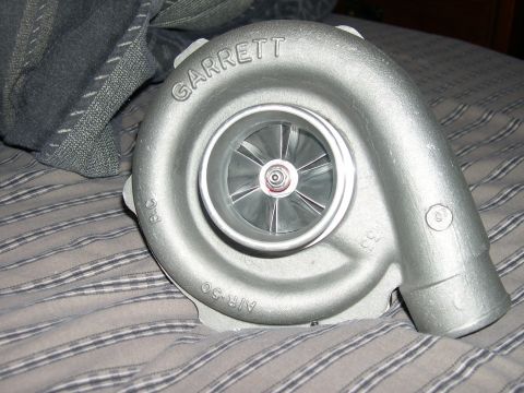 1997 Ford Probe - A silver Garrett turbocharger is shown on a striped fabric surface.