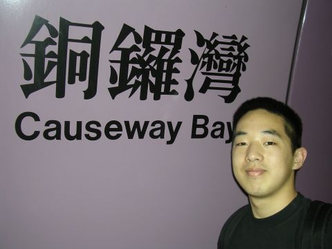 1999 Toyota Tacoma - A man stands in front of a wall with bilingual text indicating a location.