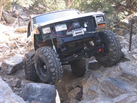 1981 Ford Bronco - This modified 1981 Ford Bronco navigates a rocky trail with its front grille removed and a winch mounted.