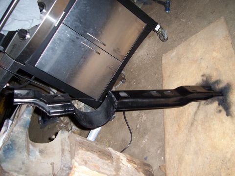 1983 Ford Bronco - A black metal crossmember part is shown on the floor, possibly for a vehicle restoration project.