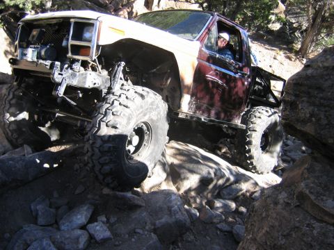 1981 Ford Bronco - This heavily modified SUV is navigating a challenging rocky terrain, its off-road capabilities.