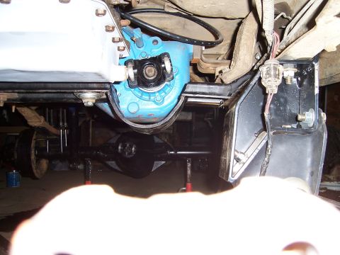 1983 Ford Bronco - The vehicle's drivetrain components are visible, supported by jack stands for maintenance or repair.