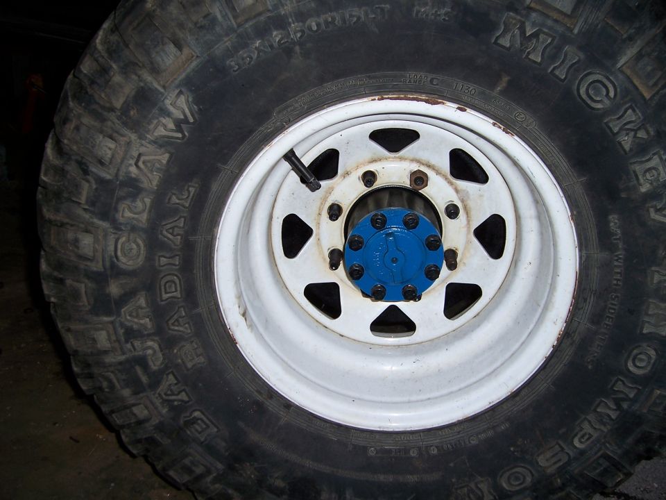 Close-up of a Mickey Thompson Baja Radial tire on a white steel wheel with a blue hub