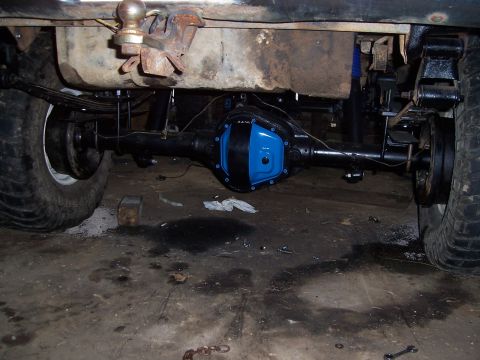 1983 Ford Bronco - The rear axle assembly of a vehicle is shown, a bright blue differential cover and suspension components.