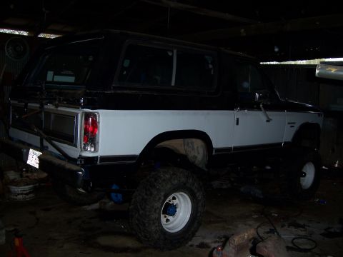 1983 Ford Bronco - This SUV has a black top and a white lower body, with prominent off-road tires.