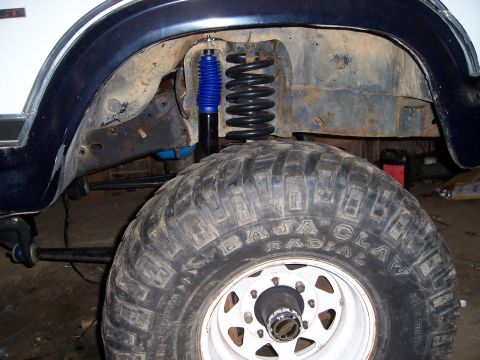 1983 Ford Bronco - Front suspension and tire detail, likely from an off-road vehicle.