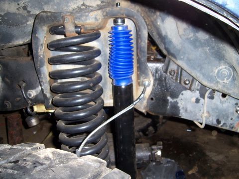 1983 Ford Bronco - Close-up of a vehicle's suspension system, showing a coil spring and shock absorber.