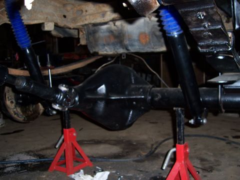 1983 Ford Bronco - Rear axle assembly and shocks are supported by jack stands, ready for work.