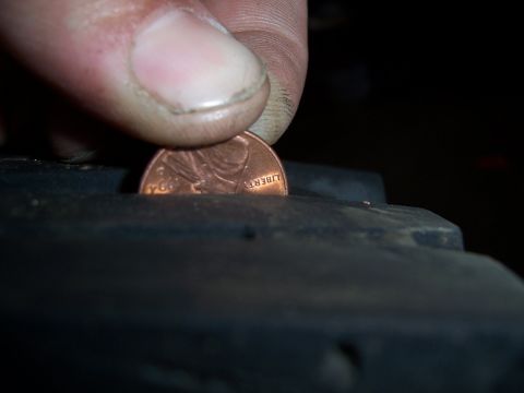 1983 Ford Bronco - A penny is used to gauge the tread depth of a tire.