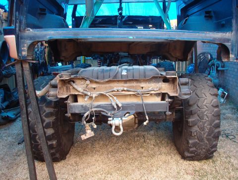 1994 Ford Bronco - The rear chassis and suspension of a vehicle are exposed, with large tires mounted.