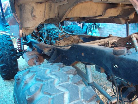 1994 Ford Bronco - Undercarriage view of a vehicle, showing the frame, transmission, and large off-road tires.