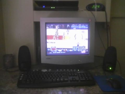 2000 Ford Crown Victoria - A computer setup displays a basketball game on its screen, with a digital clock showing the time.