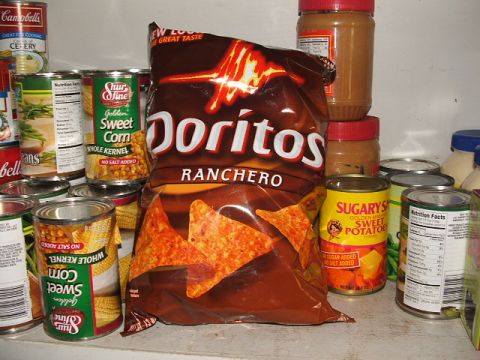 1966 Ford Ranchero - A bag of Doritos Ranchero chips is surrounded by various canned food items on a shelf.