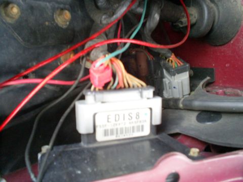1995 Ford Crown Victoria - Close-up of an engine control module and wiring harness, showing various colored wires and connectors.