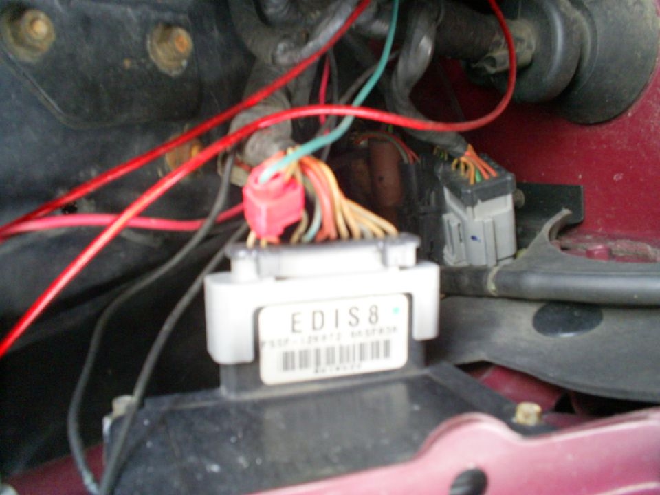 Engine control module labeled EDIS8 with wiring harness connected, red and orange wires visible