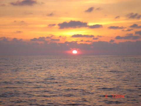 1992 Ford C-250 (Centurion Conversions) - Ocean sunset with clouds and a watermark for SUPERMOTORS.net.