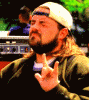 1991 Ford LTD Crown Victoria - Kevin Smith is seen outdoors, wearing a backward baseball cap and making a hand gesture.