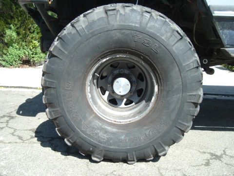 1989 Ford Bronco - Close-up of a large, aggressive off-road tire and wheel assembly on a vehicle.