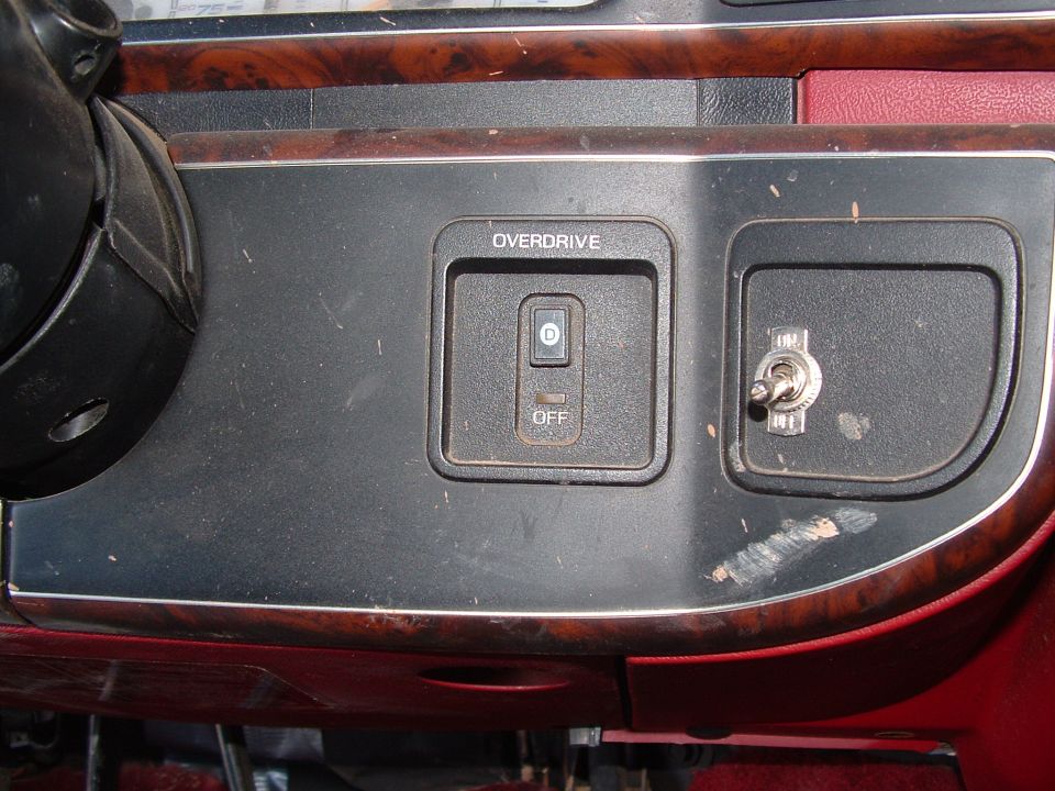Console with OVERDRIVE D/OFF rocker switch and a metal ON toggle switch, woodgrain trim.