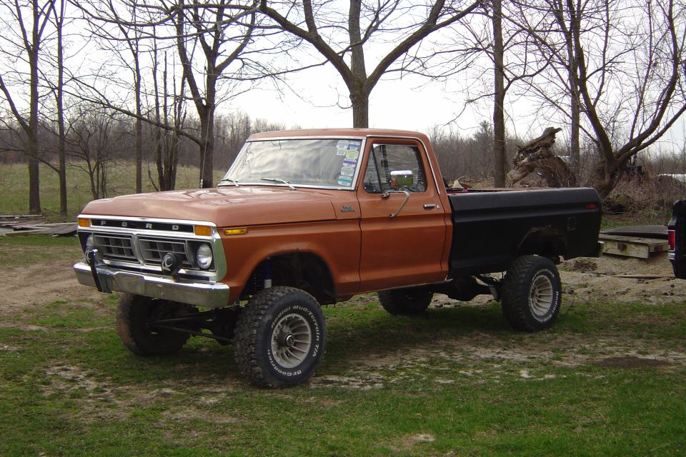 1977 Ford F-150, orange and black lifted pickup truck, 3/4 front view