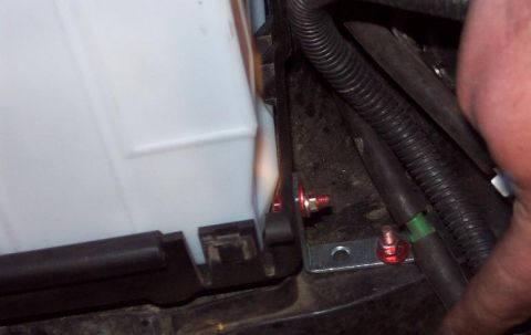 1985 Ford Crown Victoria LTD - Close-up of a battery tray mounting bracket with red hardware, the SuperMotors logo at the bottom.