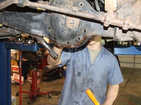 1986 Ford Bronco - Close-up of a mechanic servicing a vehicle's differential, likely during maintenance or repair.