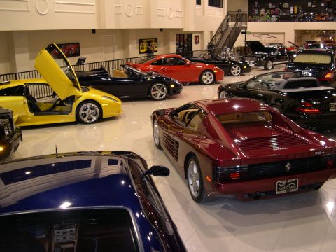 2002 Ford Focus - A maroon sports car is parked in a showroom with several other luxury vehicles.
