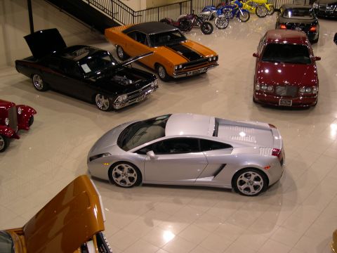 2002 Ford Focus - A collection of vehicles, including a silver Lamborghini, are displayed indoors.