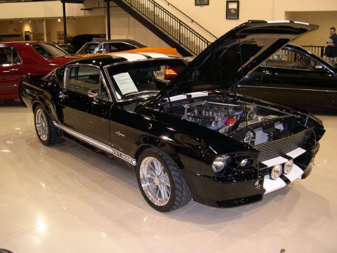 2002 Ford Focus - Black 1967 Shelby GT500 with hood open, parked indoors with other vehicles.