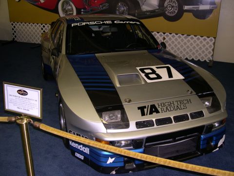 2002 Ford Focus - A Porsche race car is displayed indoors with a sign detailing its history and price.