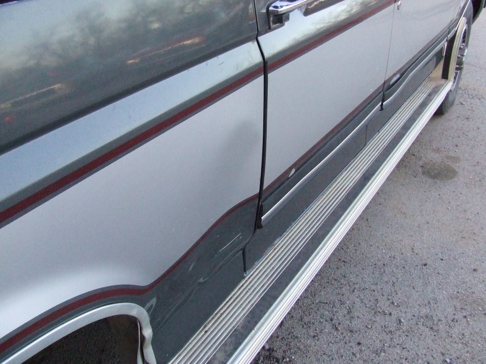 Side body detail of two-tone gray vehicle with red pinstripe and chrome running board